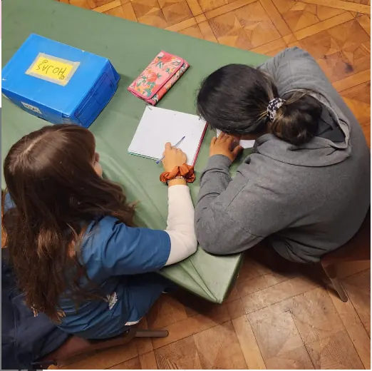Una estudiante trabaja en una actividad de integración escolar, vista desde arriba