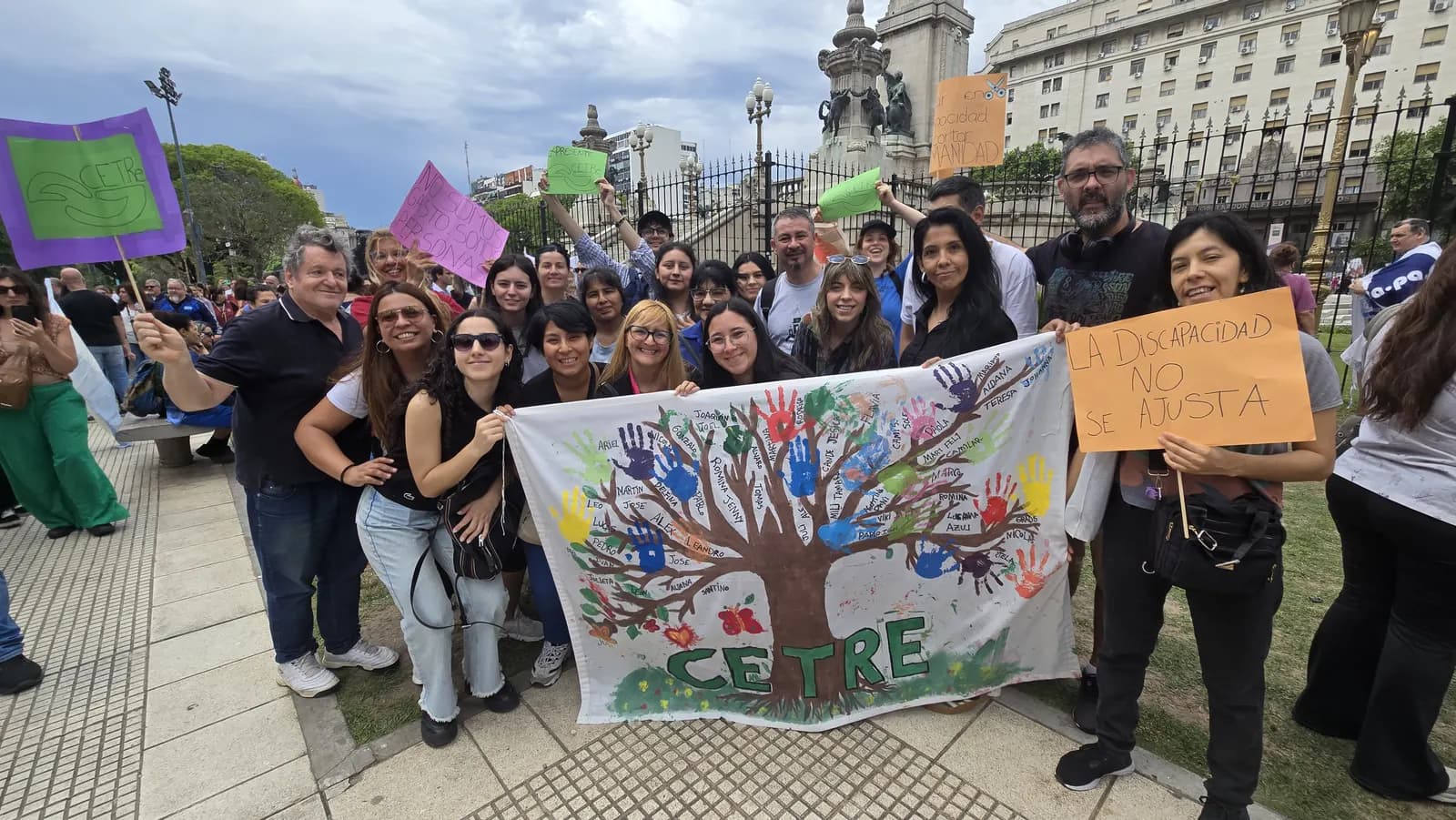 Equipo y concurrentes de CETRe con la bandera del árbol de manos pintadas en una marcha por los derechos de las personas con discapacidad