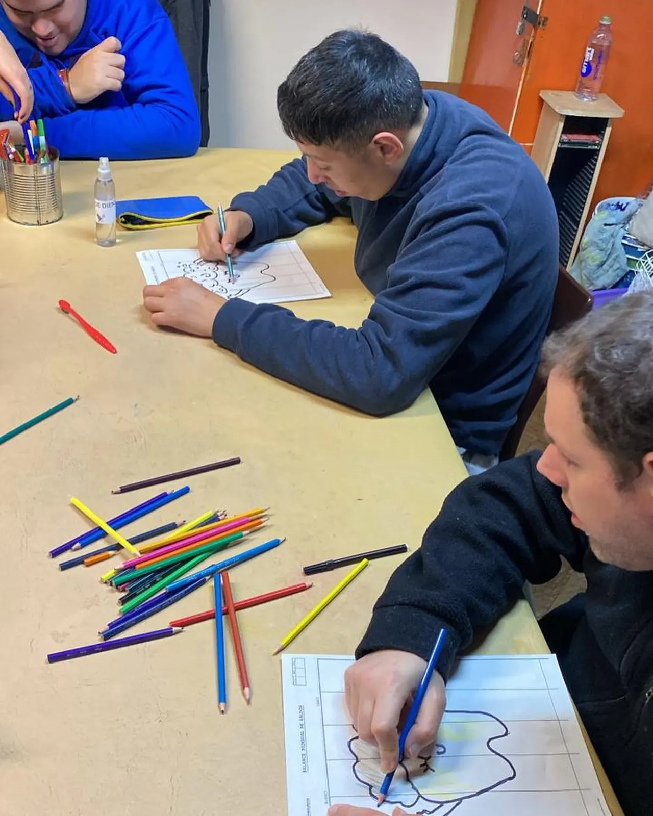 Lápices de colores y dibujos en una mesa de taller
