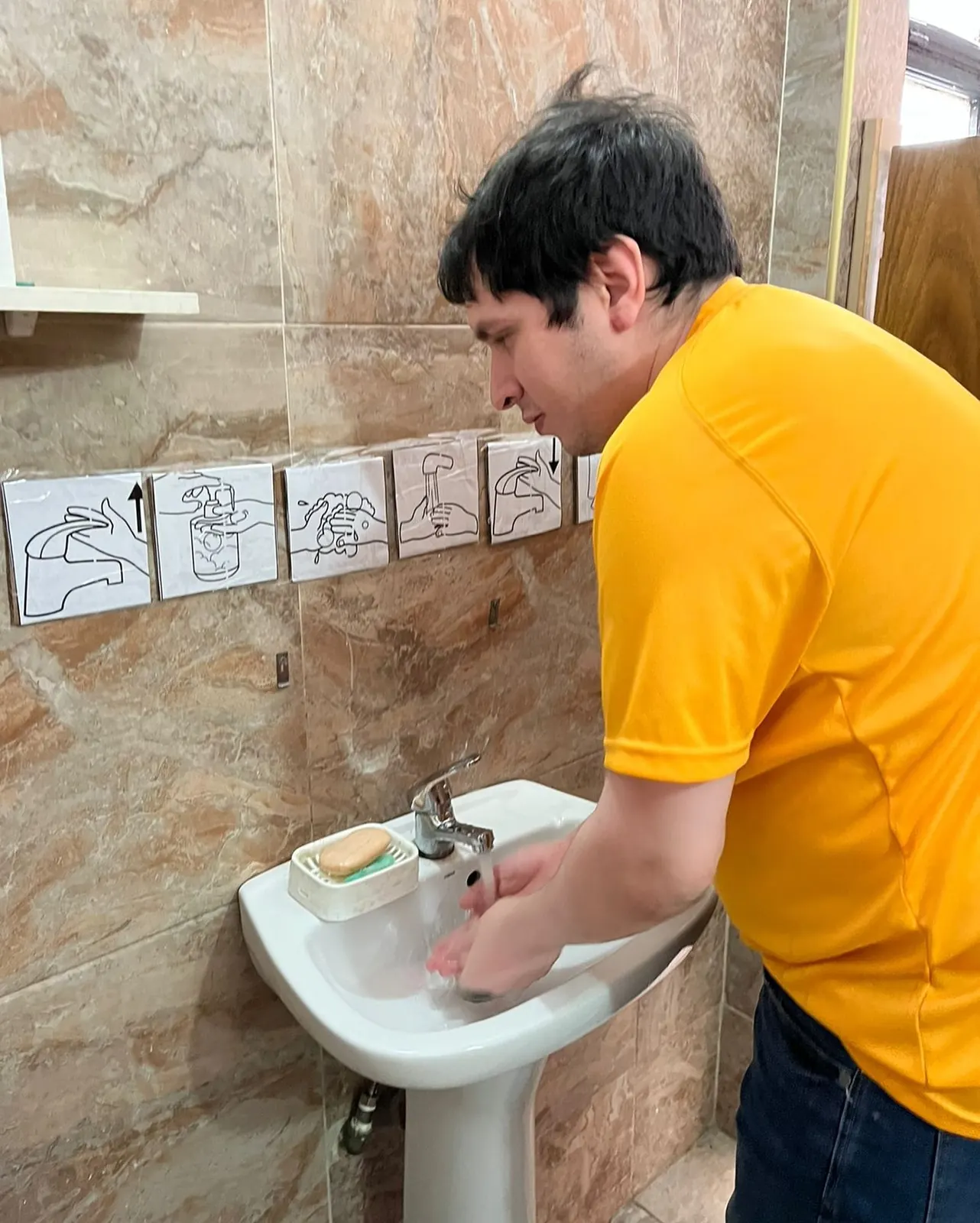 Un concurrente se lava las manos siguiendo los pictogramas