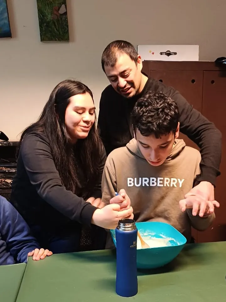 Taller de cocina: un concurrente mezcla con ayuda de una profesional